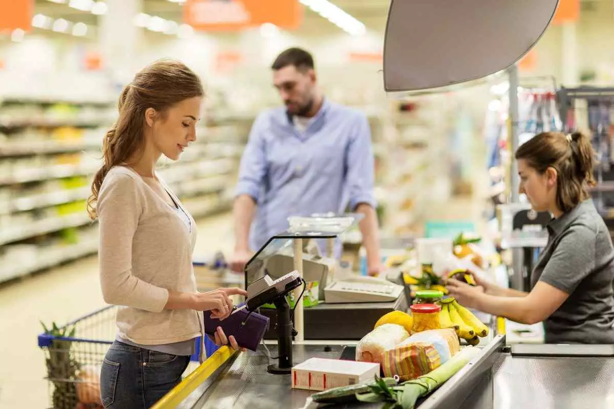 Young adult paying for groceries. 