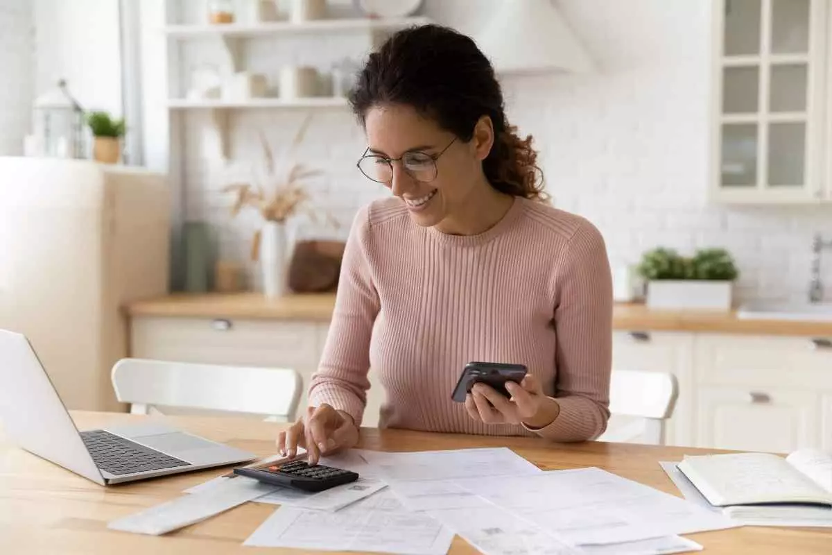 Happy woman calculating finances.