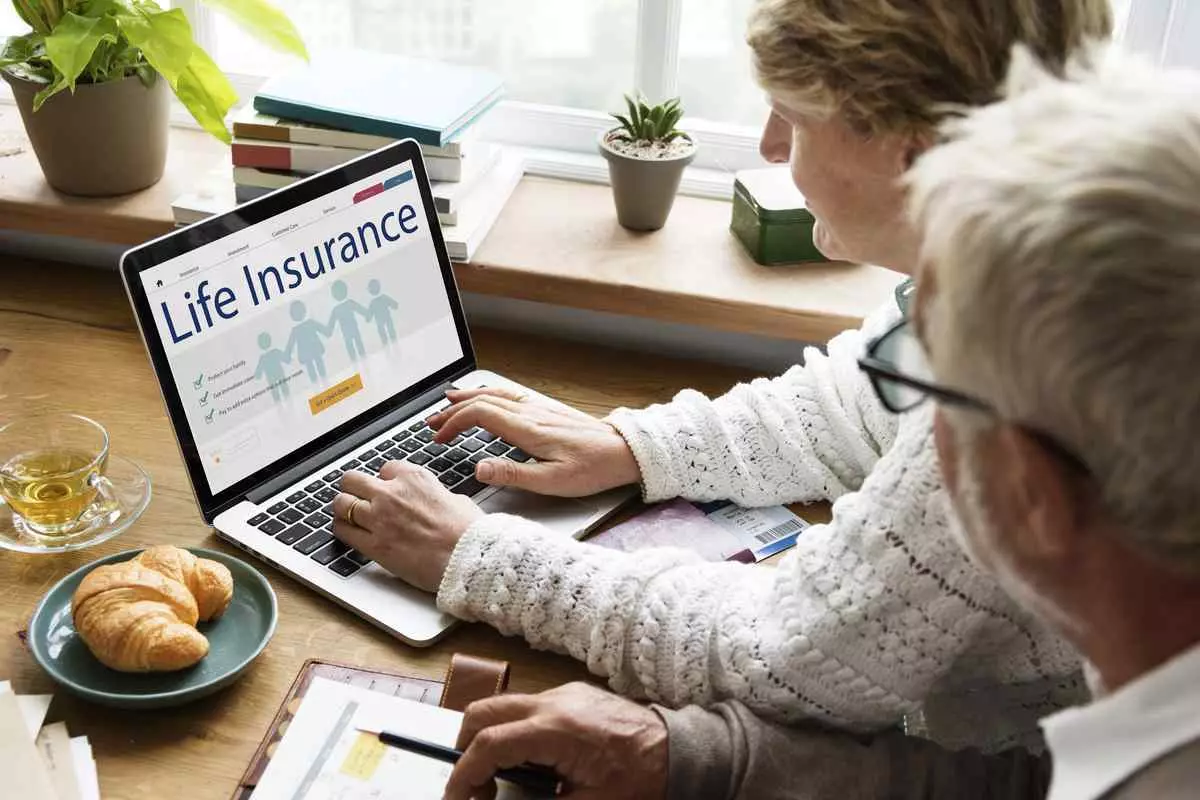 older couple looking at the life insurance website on their laptop