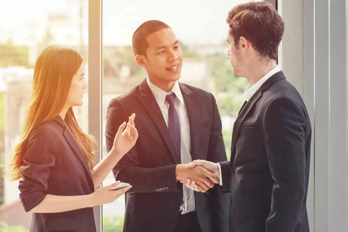 Businessman shaking hands accompanied by a translator