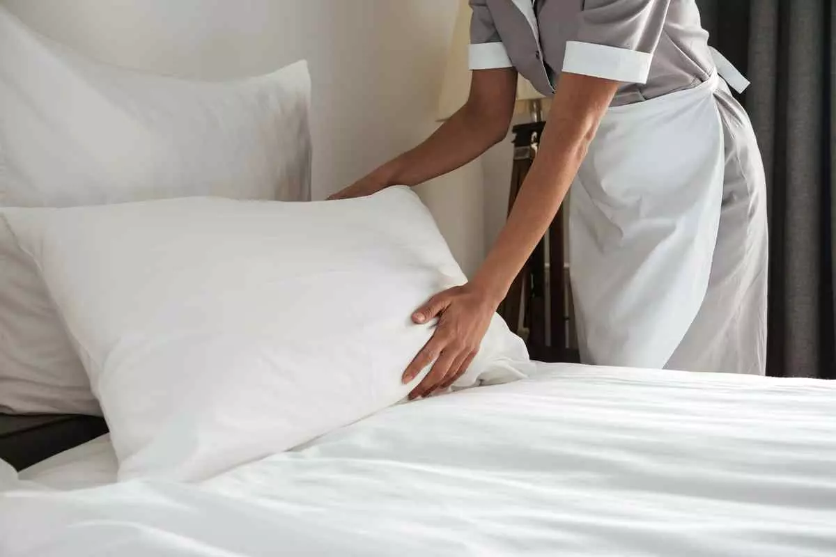 A hotel housekeeper making a bed. 