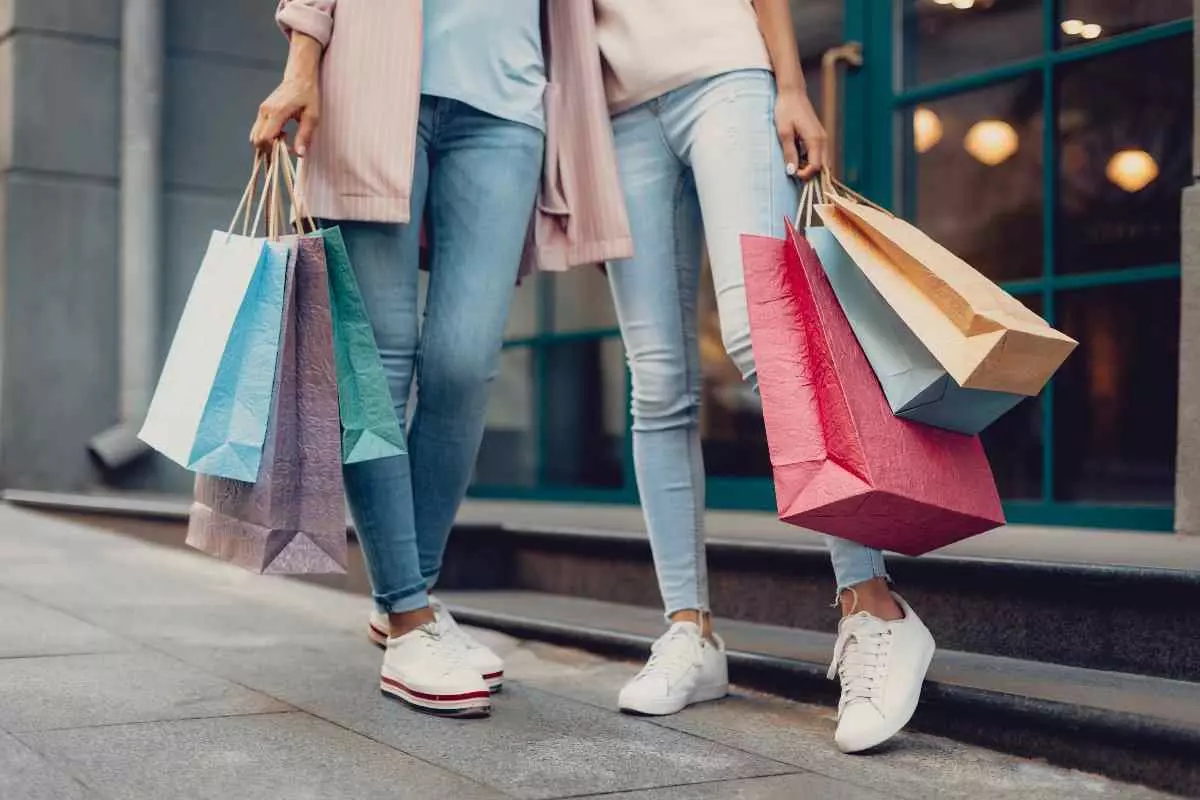 Individuals holding many shopping bags.