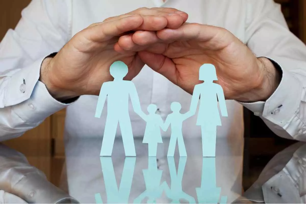 Hands defending paper family cutout, insurance concept