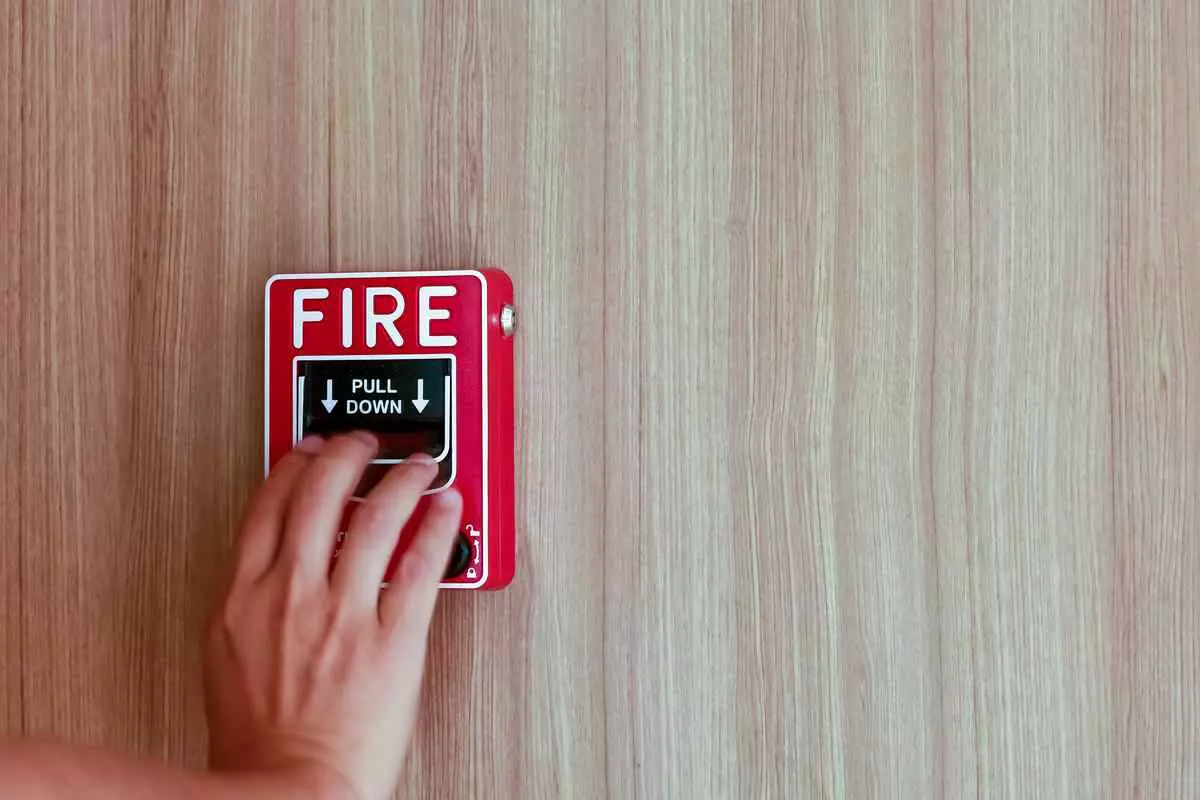 A hand pulling a fire alarm.