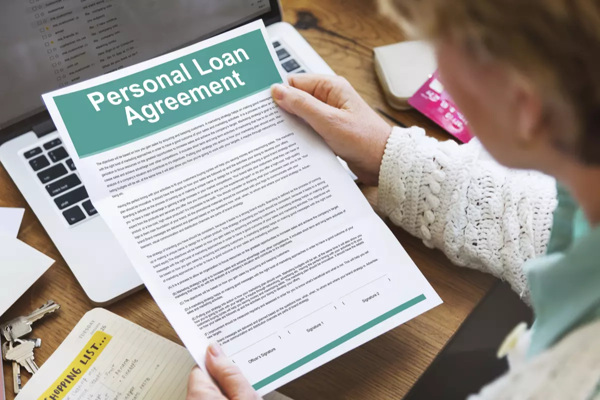 someone holding a personal loan agreement paper.