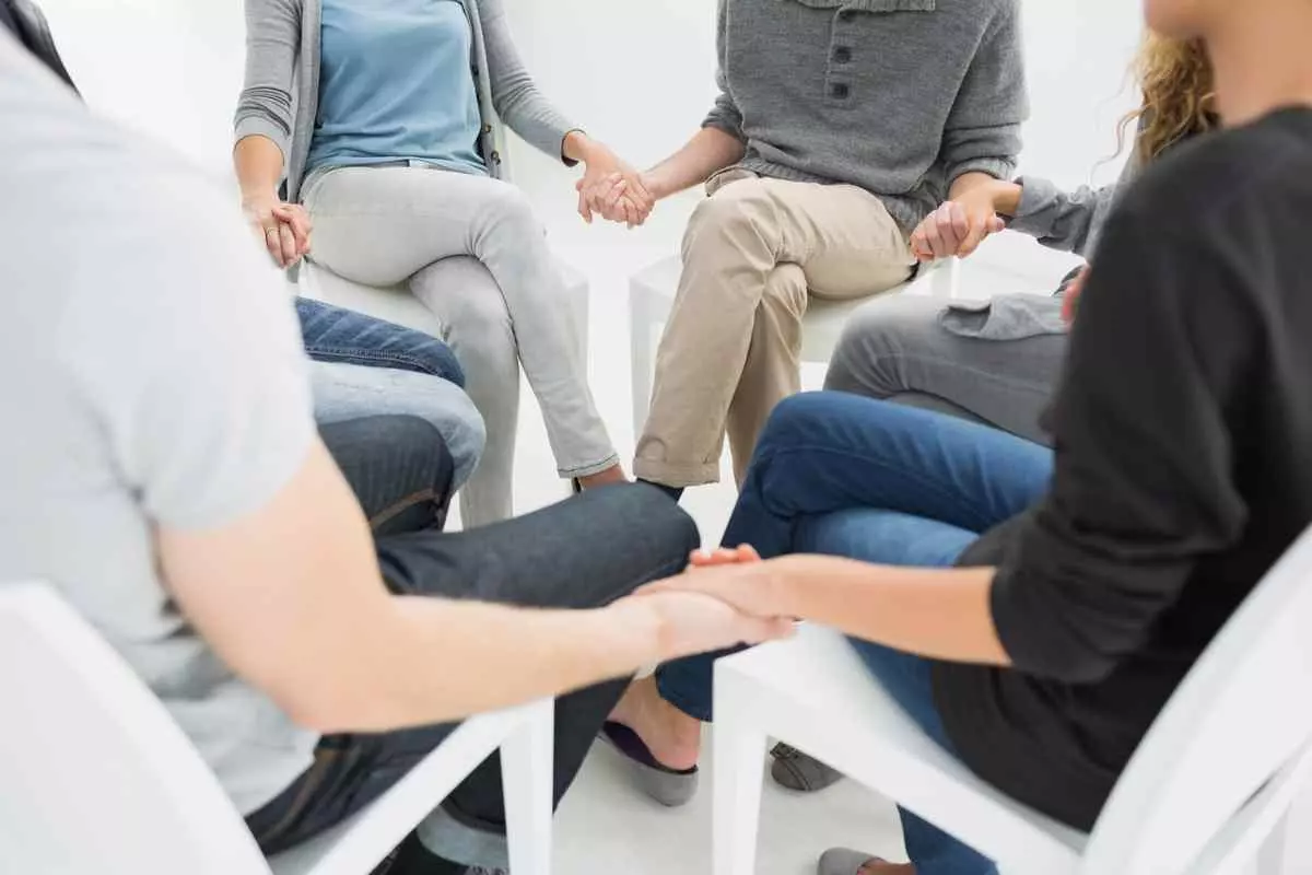 A group of staff holding hands in support