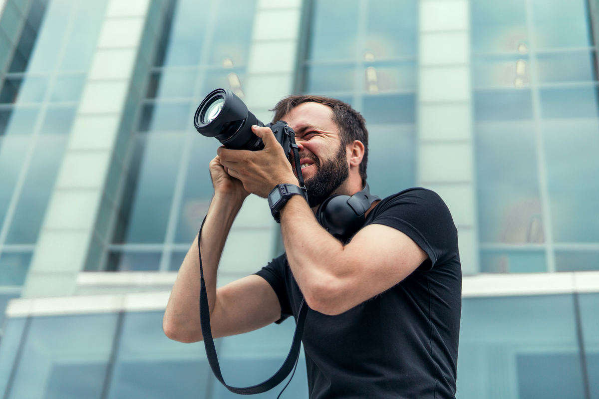A photographer pointing a camera lens. 