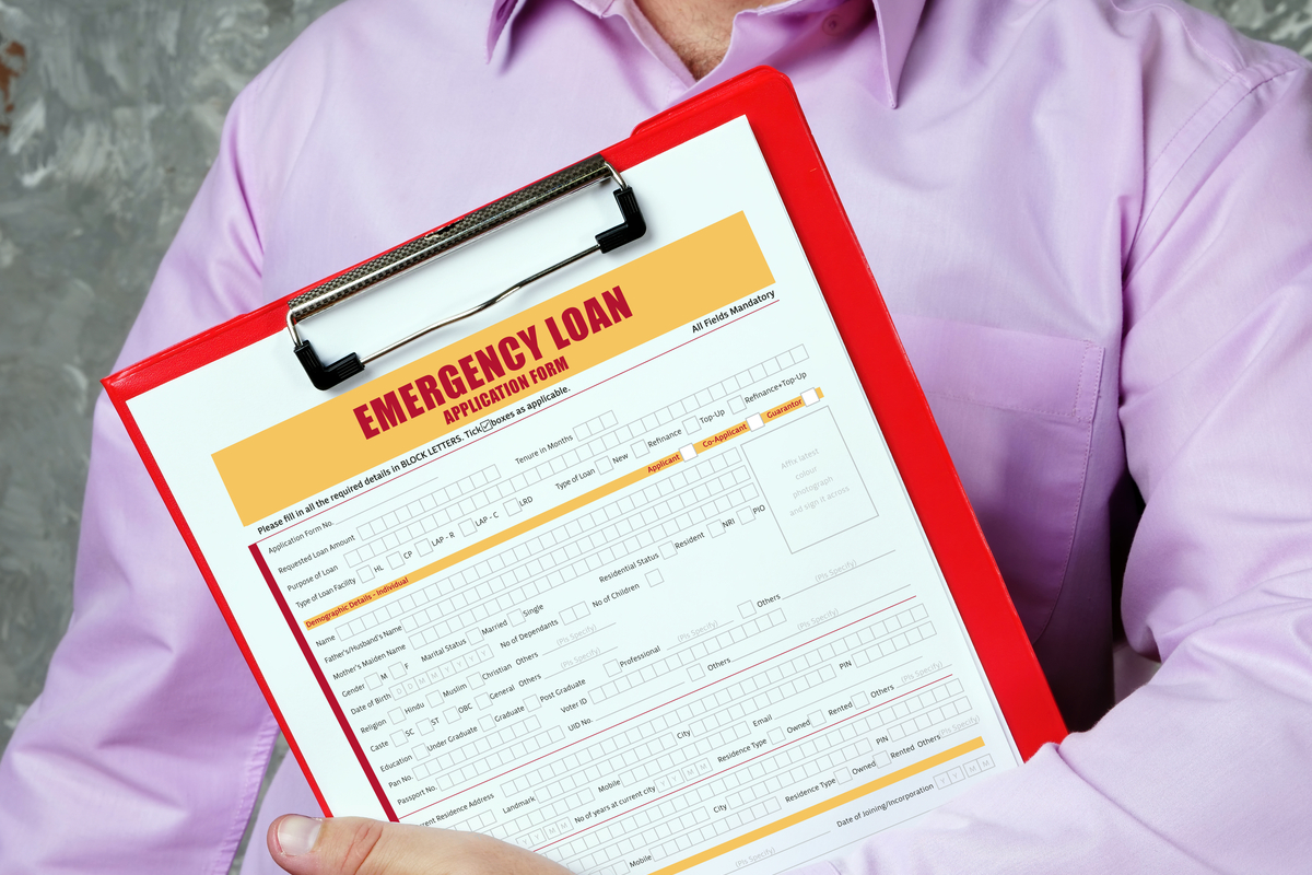 A lender holding a clipboard with an emergency loan application attached