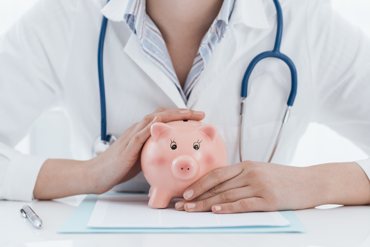 A doctor holding a piggy bank.