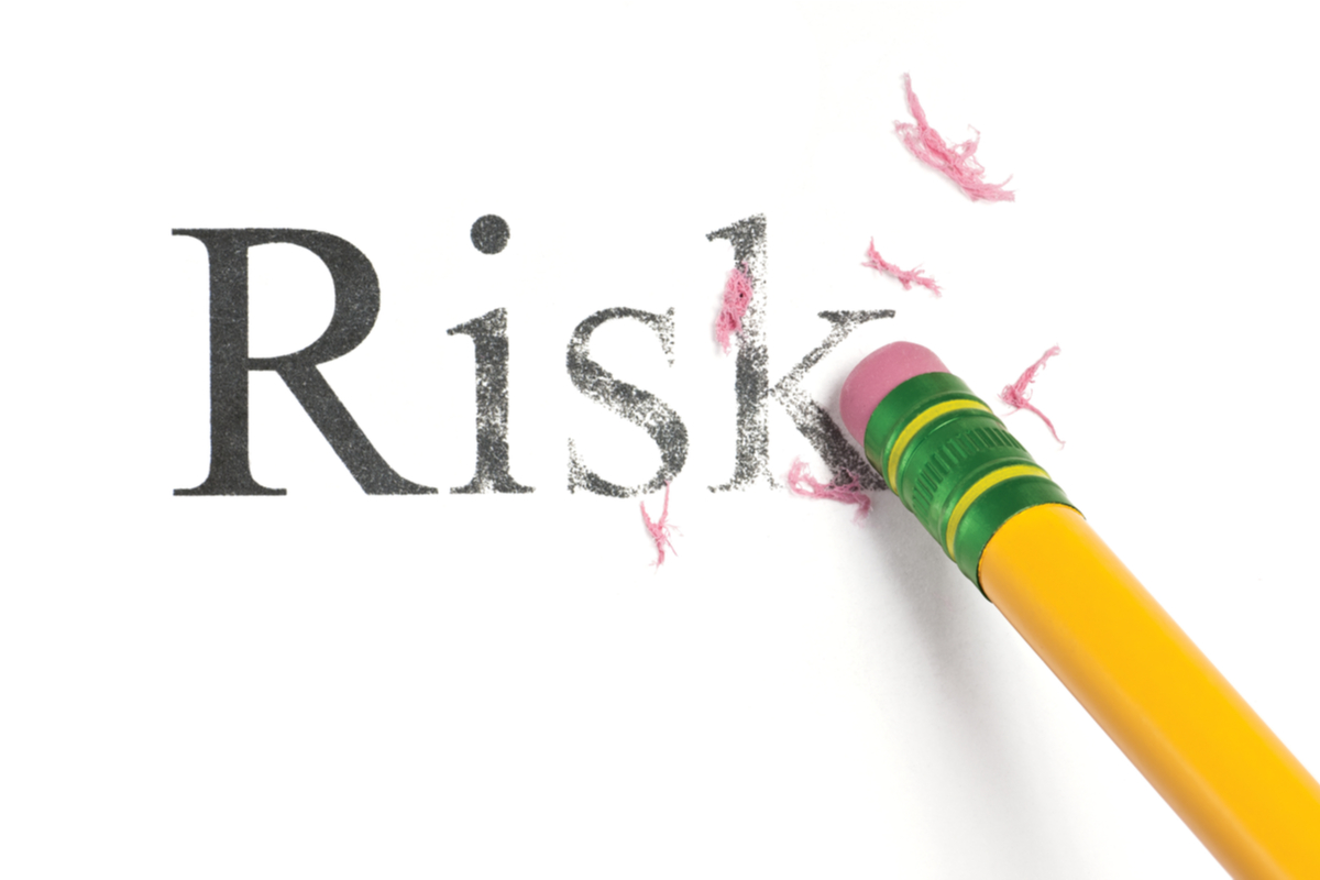 A pencil eraser erasing the word "risk"