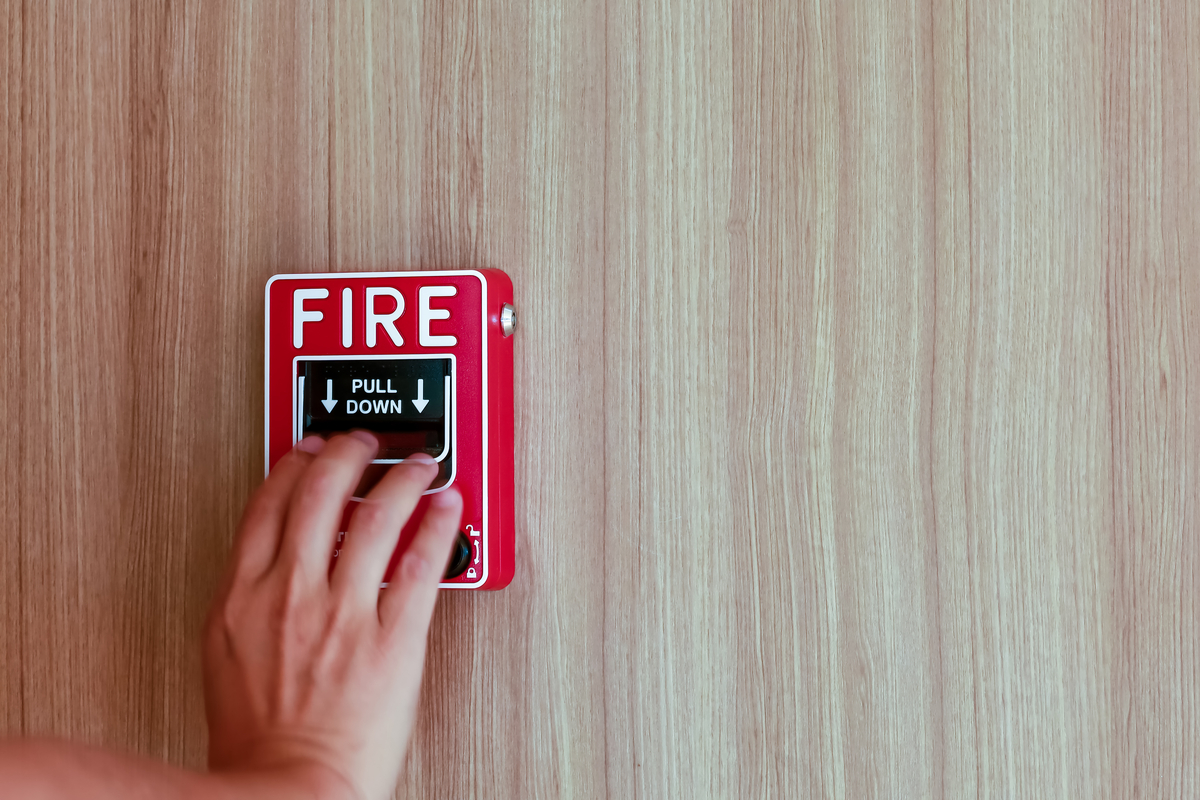 A hand pulling a fire alarm.
