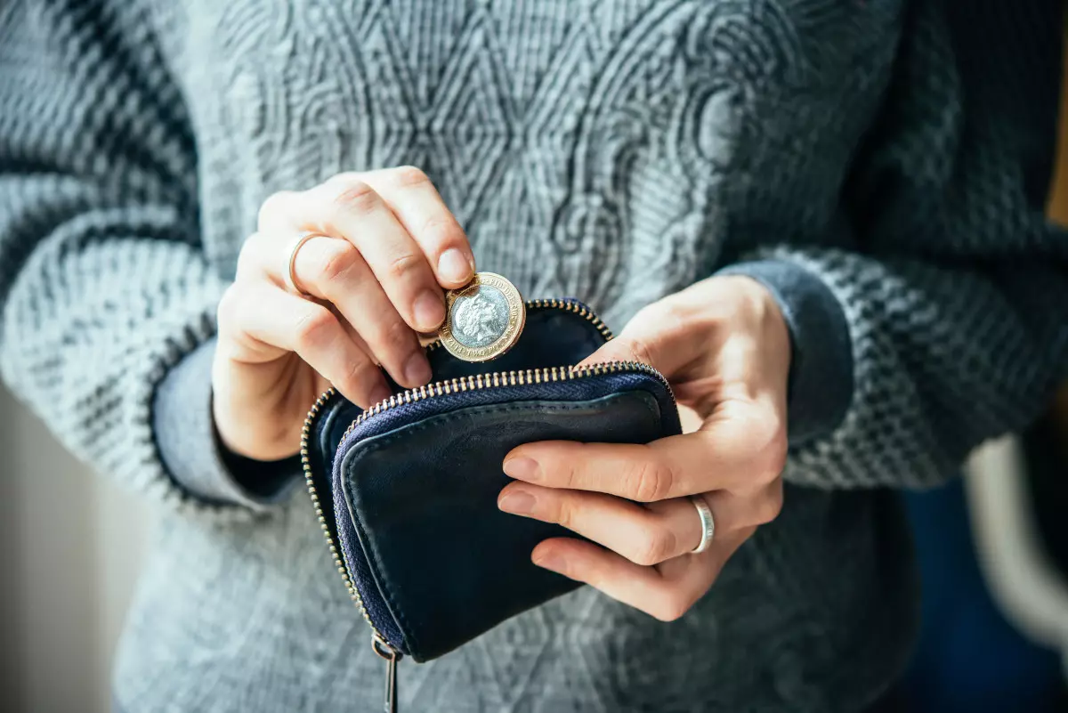 Someone taking the last coin out of their coin purse.