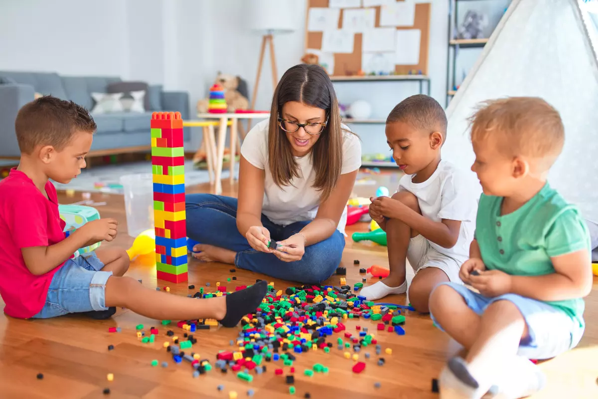 A childcare worker playing with children.