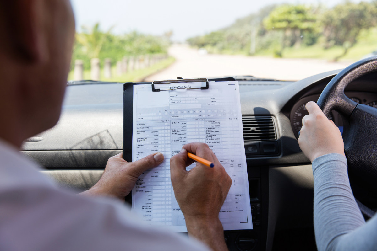 A driving instructor conducting a test with their student in the car. 