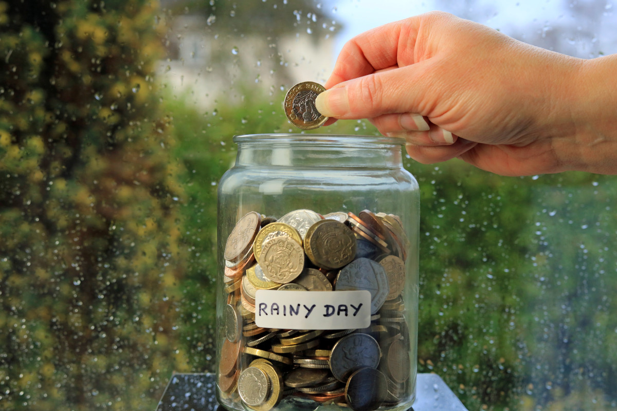 A jar labelled "rainy day" with pounds in it. 