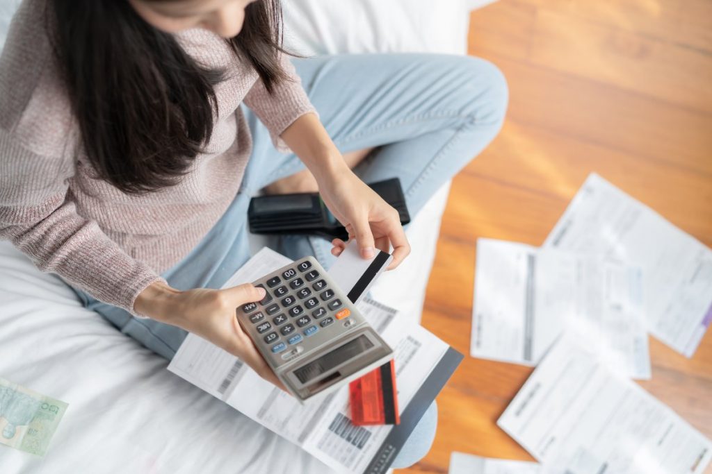 Woman holding calculator and bills.