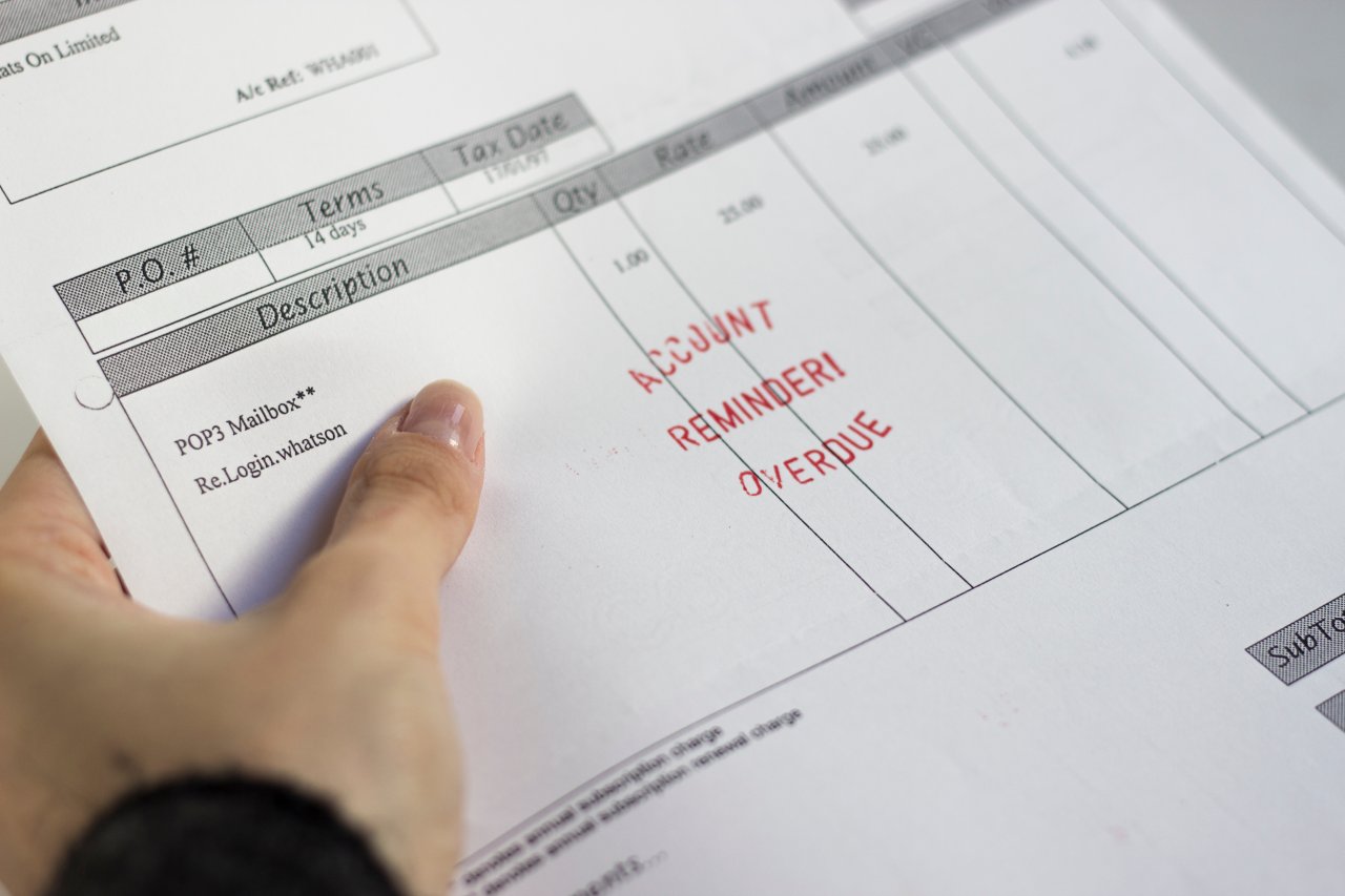 Close up on hand holding overdue bill reminder