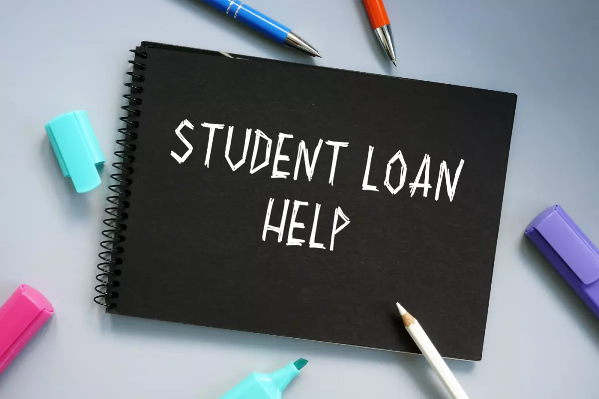 "Student Loan Help' written on notepad