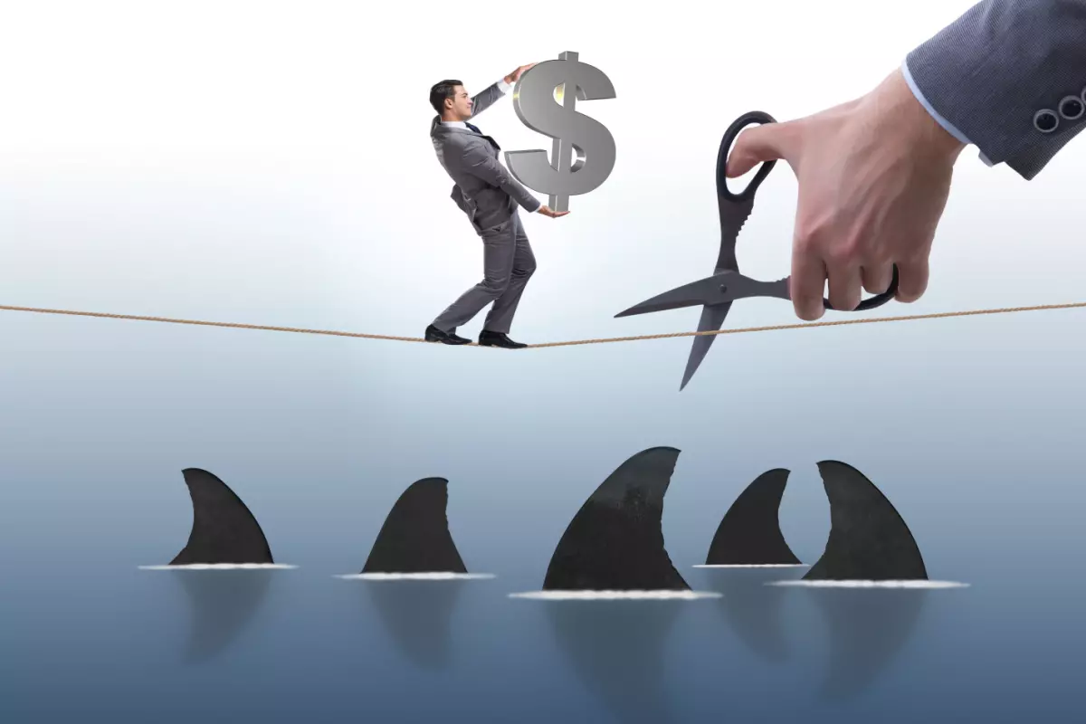 Graphic of a man holding a dollar sign walking on a tightrope with sharks below